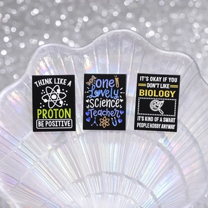 Set of 3 creative science enamel pins with biology and physics motifs on black metal