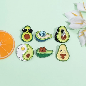 Detail of six avocado enamel pins featuring a cat, astronaut, and heart on green background