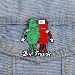 Close-up of cartoon leaf and lighter enamel pin on denim jacket with Best Friends text