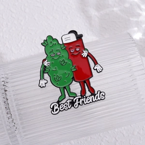 Close-up of Best Friends lighter and leaf enamel pin on textured glass surface