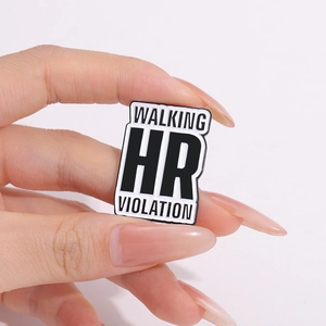 Detailed shot of enamel pin featuring humorous Walking HR Violation text design
