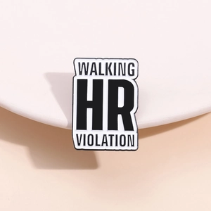 Detail of the WALKING HR VIOLATION enamel pin on a minimalist white curved display stand