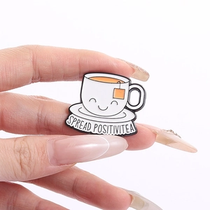Détail de la broche en émail en forme de tasse de thé avec smiley et sachet de thé