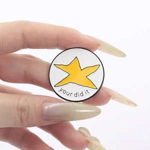 Badge métallique étoile jaune avec lettrage your did it sur fond blanc épuré