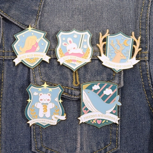 5er-Set Emaille-Anstecknadeln mit Tiermotiven wie Hase und Wal auf einer Jeansjacke