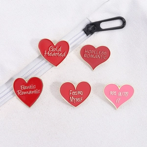 Set of five cartoon heart enamel pins in red and pink with golden metal edges