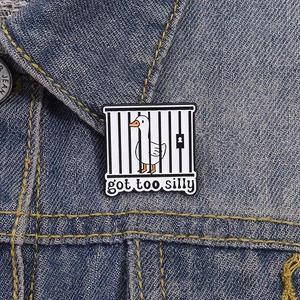 Broche en émail canard blanc avec texte 'got too silly' sur une veste en jean