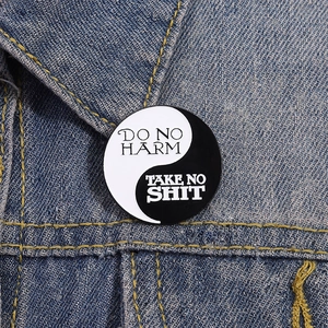 Nahaufnahme der Yin Yang Emaille-Anstecknadel mit Zitaten auf einer Jeansjacke