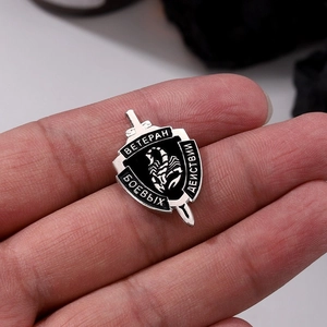 Shield-shaped punk metal badge with scorpion and sword design in black and silver