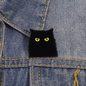 Mignonne épingle en émail de chat noir avec yeux jaunes sur col de veste en jean