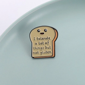 Close-up of a cartoon toast enamel pin with funny gluten-themed quote and cute face
