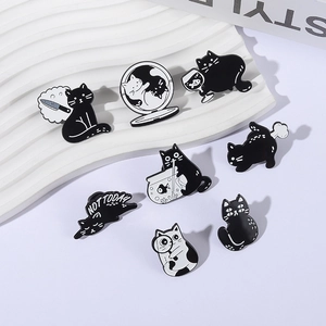 Collection de pin's chats émaillés noir et blanc sur présentoir blanc