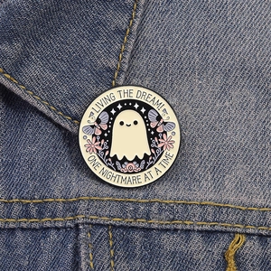 Spilla smaltata fantasma su giacca di jeans con testo Living the Dream e decorazioni