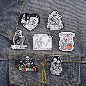 Macro view of cartoon skull and cat enamel pins on blue denim fabric jacket
