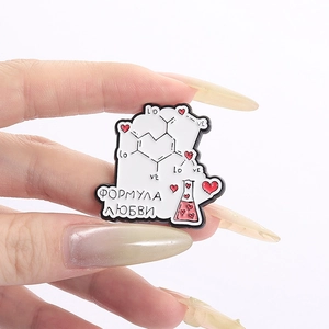 Kreative Chemie-Emaille-Anstecknadel mit Herz und Becher, in der Hand gehalten