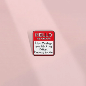 Detail of red and white enamel pin featuring Inigo Montoya quote from The Princess Bride
