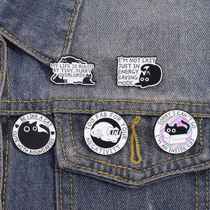 Set of 5 black cat enamel pins featuring funny quotes on a blue denim jacket pocket