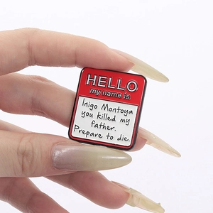 Macro shot of Inigo Montoya movie quote enamel pin with red name tag design details