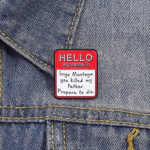 Red and white enamel pin with movie quote on a blue denim jacket collar