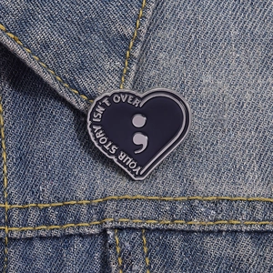 Your Story Isn't Over heart semicolon enamel pin badge on blue denim jacket collar