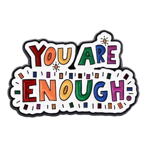 Detail showing the colorful YOU ARE ENOUGH enamel pin with creative handwritten font