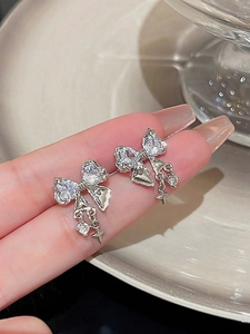 Gros plan de boucles d'oreilles nœud avec étoiles en zircon et glands pendants