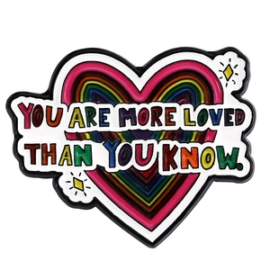 Detail of rainbow heart enamel pin with You Are More Loved Than You Know quote
