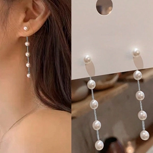 Close-up of elegant long pearl tassel earrings with vertical link chain design
