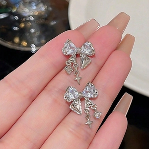 Boucles d'oreilles nœud argenté avec pendentifs étoile en zircon et cristaux brillants