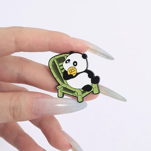 Close-up of a cute cartoon panda enamel pin on a green bamboo chair for clothes decoration