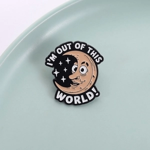 Cartoon moon face enamel pin with I'm Out Of This World text on a ceramic tray