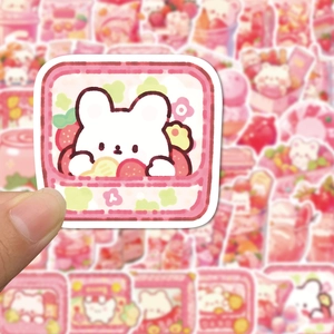 Close-up of a pink bear and strawberry doodle sticker held to show size and texture details