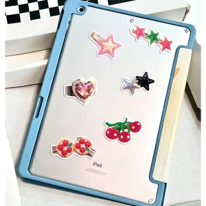 Cute Y2K style stickers and hair clips set on a tablet back with star and cherry shapes