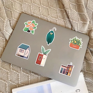 Flat design plant and architecture stickers on a laptop with cozy lifestyle background