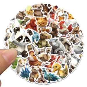 Close-up showing a hand holding a low-poly origami animal sticker among a creative set