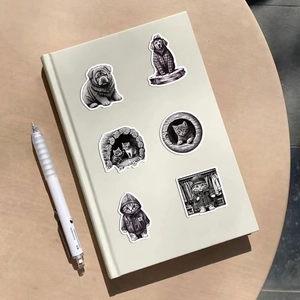 Black and white hand-drawn animal stickers on a notebook with a minimalist white pen