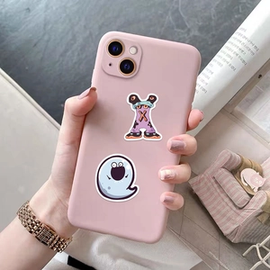 Pink silicone iPhone case with cute cartoon monster stickers on a magazine background