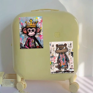 Close-up of artistic Basquiat style graffiti stickers on a yellow textured suitcase surface
