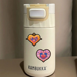 Détail d'autocollants cœur gothique étanches sur une bouteille isotherme blanc crème