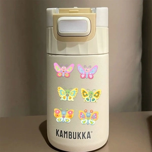 Detail of colorful butterfly stickers on cream matte stainless steel vacuum insulated bottle