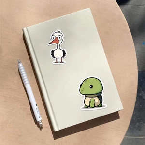 Détail d'autocollants d'animaux imperméables sur un carnet avec motifs de cigogne et tortue