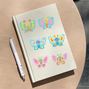 Close-up of colorful cartoon butterfly stickers applied to a notebook for DIY decoration