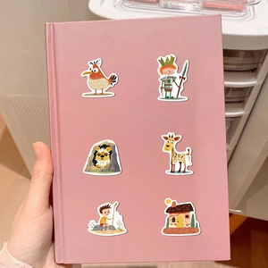 Close-up of colorful cartoon caveman and animal stickers on a pink notebook cover