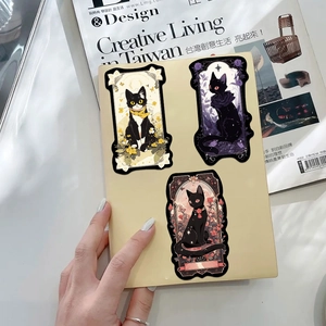 Dettaglio degli adesivi gotici con gatto nero e motivi floreali su una copertina