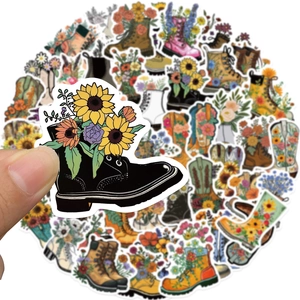 Hand holding floral vintage boot stickers with sunflowers and roses on a bright background