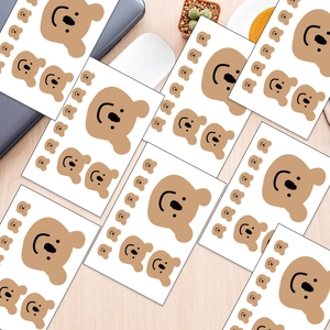 Macro view of cute brown bear stickers in various sizes for DIY journal decoration