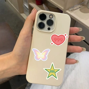 Detail of cream phone case with colorful heart, butterfly and star stickers featuring 999 text
