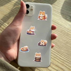 Close-up of cute shiba inu stickers applied on a white smartphone back cover