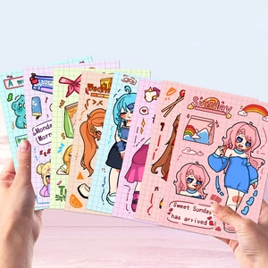 Hand holding a fanned out set of colorful cartoon girl stickers for DIY journaling deco