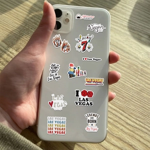 Las Vegas themed stickers displayed on a smartphone case over a natural wooden table